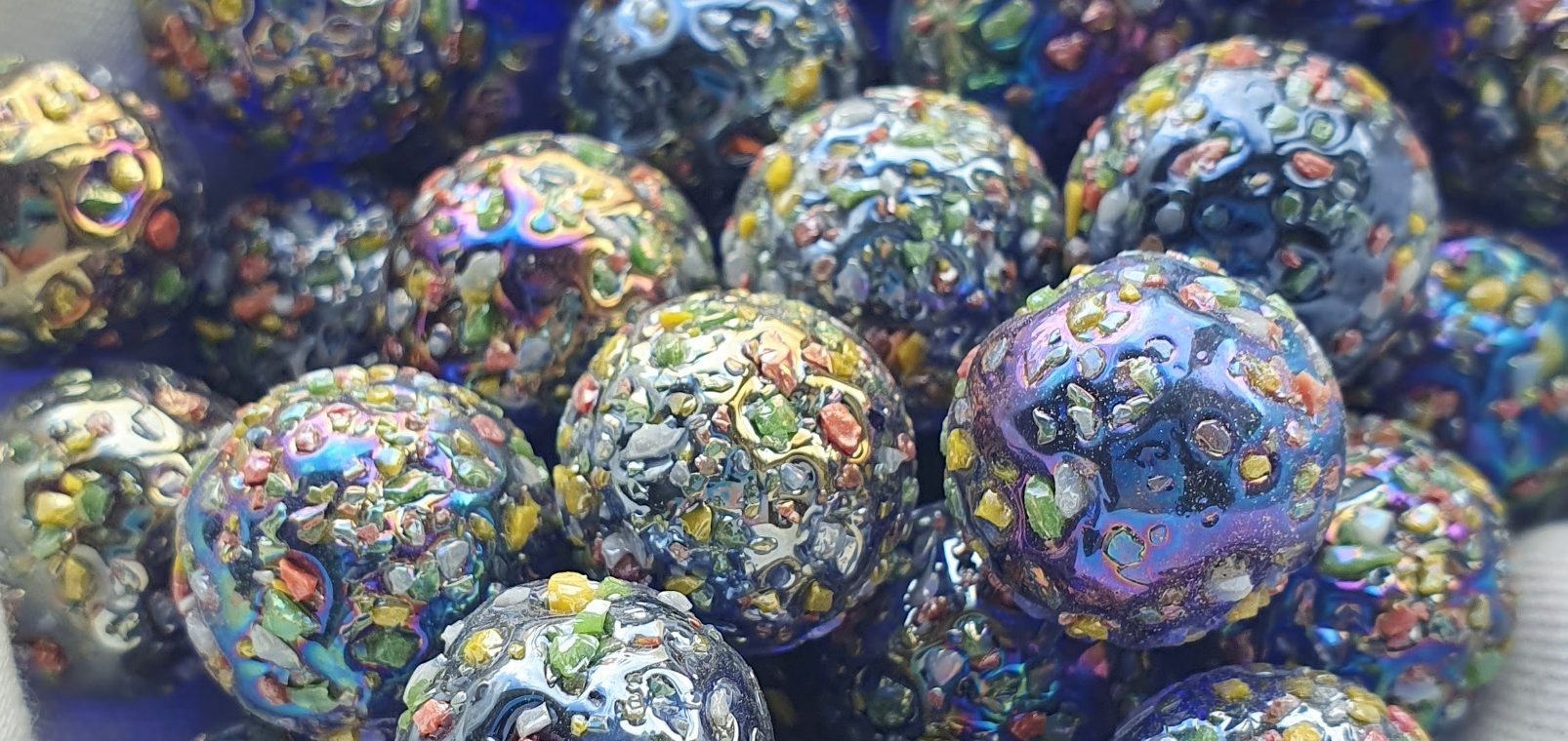 Glitterbomb glass marbles Beautiful glass marbles in the Glitterbomb style, which is dark blue with a shiny iridescent finish and a rainbow speckled texture.
